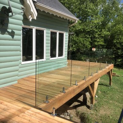 White cedar deck and glass railing in Val-des-Lacs